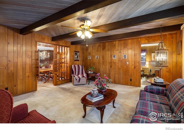 living room featuring beam ceiling, light colored carpet, and wooden walls