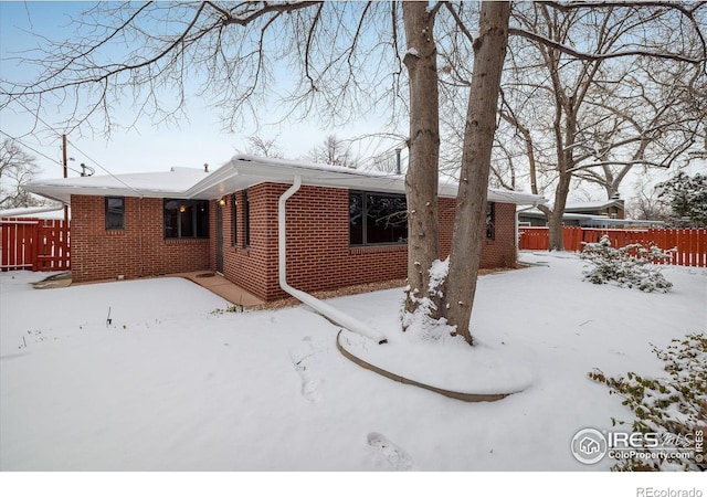 view of snow covered rear of property