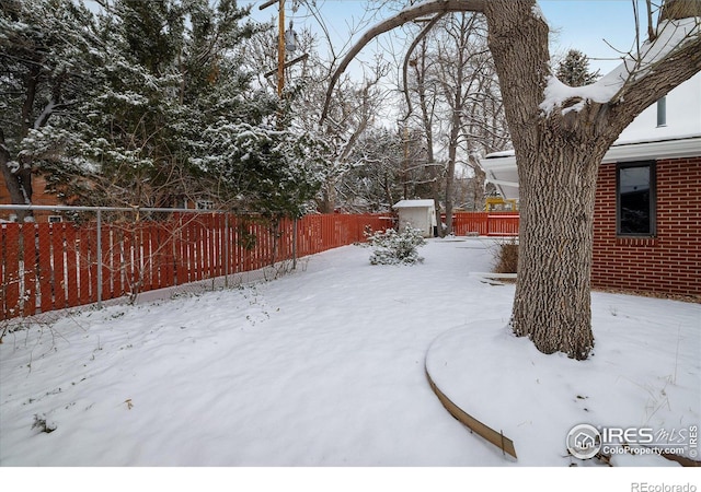 yard layered in snow with a shed