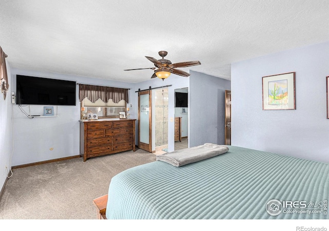 carpeted bedroom featuring a barn door and ceiling fan