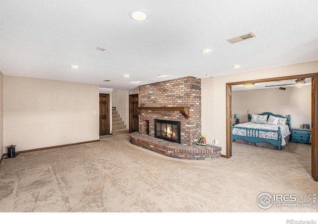 carpeted living room featuring a fireplace and a textured ceiling