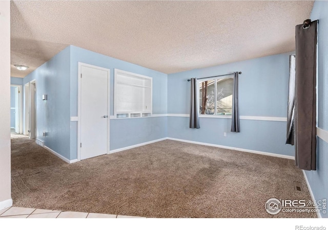 carpeted spare room featuring a textured ceiling