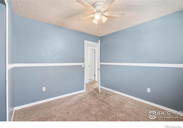 spare room featuring ceiling fan, carpet, and a textured ceiling