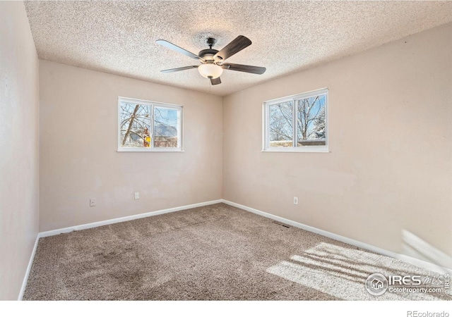 spare room featuring carpet flooring, a textured ceiling, and ceiling fan