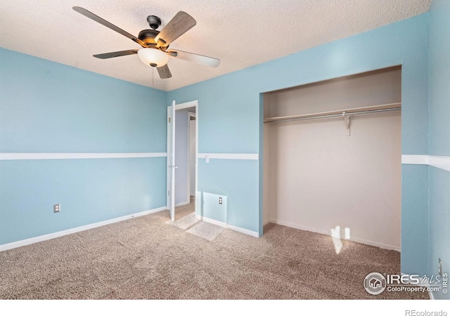 unfurnished bedroom with carpet flooring, ceiling fan, a closet, and a textured ceiling