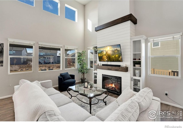 living room featuring hardwood / wood-style flooring and a towering ceiling