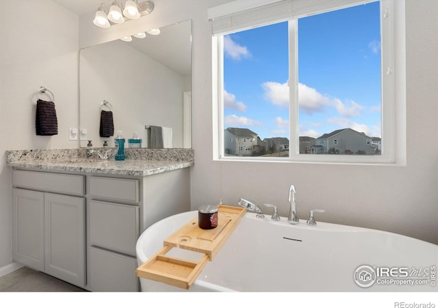 bathroom with a tub to relax in and vanity