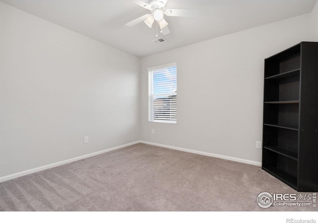 carpeted spare room featuring ceiling fan