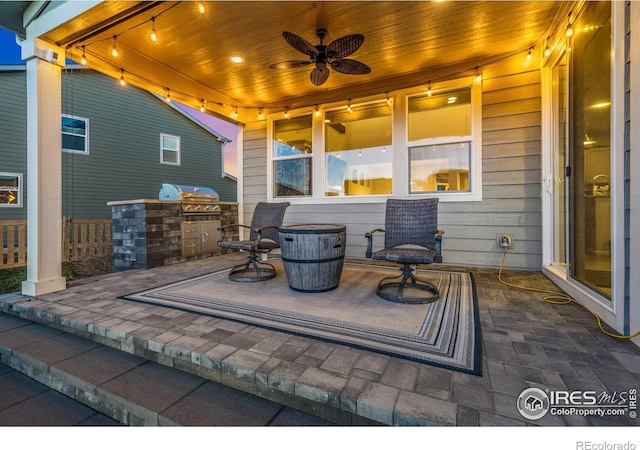 view of patio with a grill, ceiling fan, and an outdoor kitchen