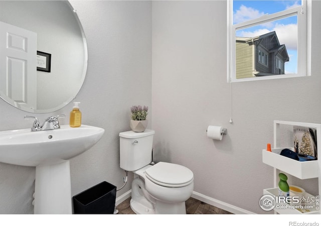 bathroom with hardwood / wood-style flooring, toilet, and sink