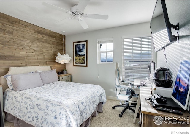 bedroom with light colored carpet, ceiling fan, and wood walls