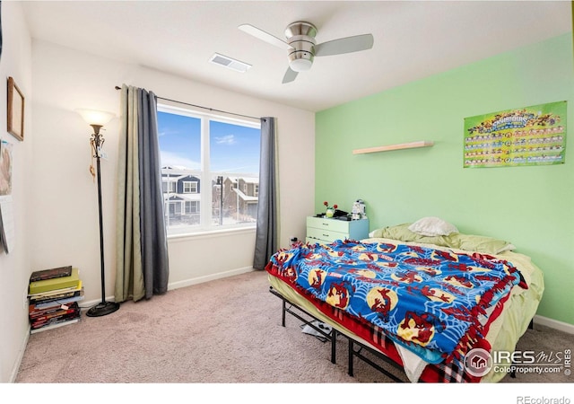 bedroom with light carpet, ceiling fan, visible vents, and baseboards