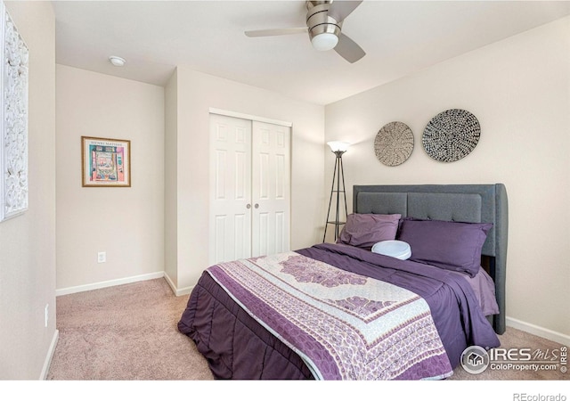 bedroom featuring a closet, light colored carpet, ceiling fan, and baseboards