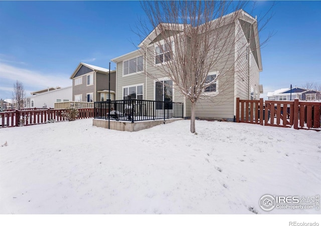 snow covered property featuring fence