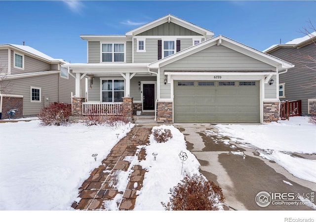 craftsman house featuring covered porch, stone siding, board and batten siding, and a garage