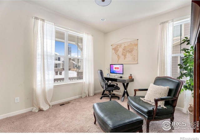 sitting room with a wealth of natural light, visible vents, light carpet, and baseboards