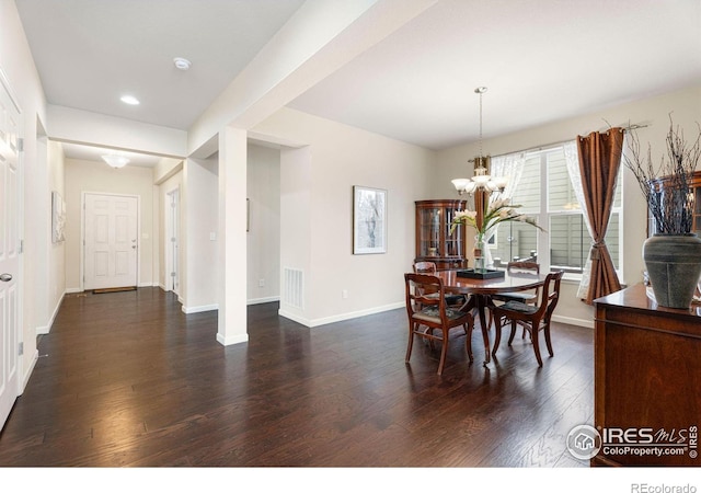 dining room with a notable chandelier, visible vents, baseboards, and dark wood-style flooring