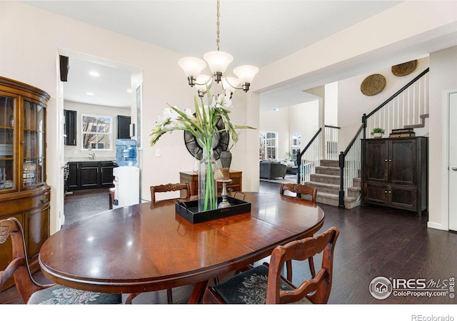 dining space featuring stairs, dark wood-style floors, and a chandelier