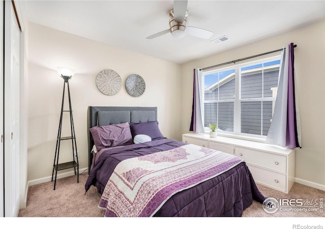 bedroom featuring a closet, visible vents, light carpet, and baseboards