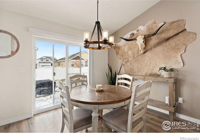 dining room with hardwood / wood-style floors and a chandelier