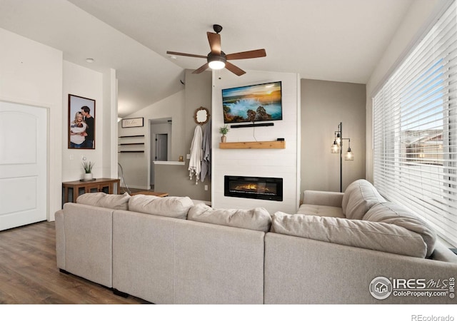 living room with ceiling fan, a large fireplace, lofted ceiling, and dark hardwood / wood-style floors