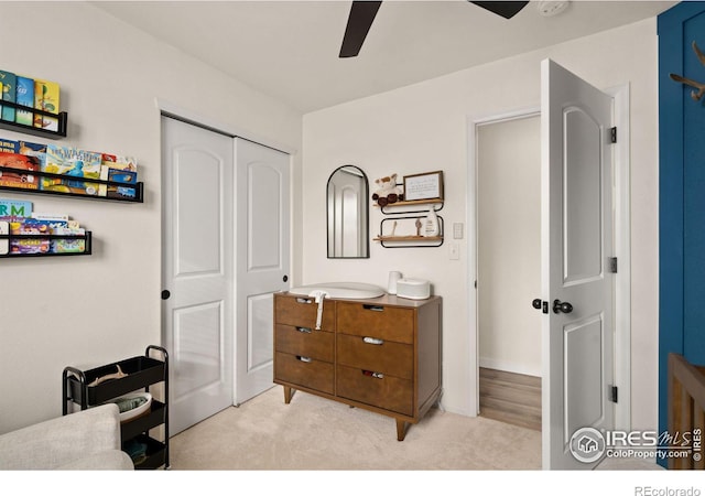 carpeted bedroom featuring ceiling fan and a closet