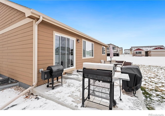 snow covered deck with a grill