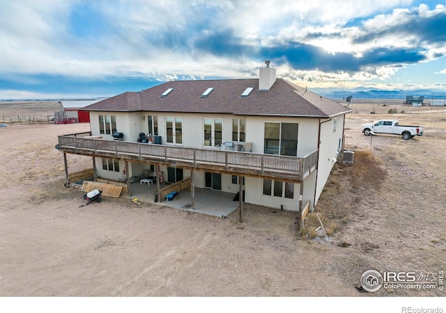 back of property featuring a mountain view, a patio, and cooling unit