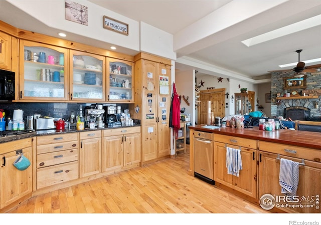 kitchen with ceiling fan, light hardwood / wood-style floors, a fireplace, and tasteful backsplash