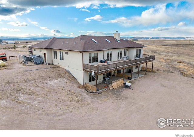 rear view of house featuring a deck with mountain view