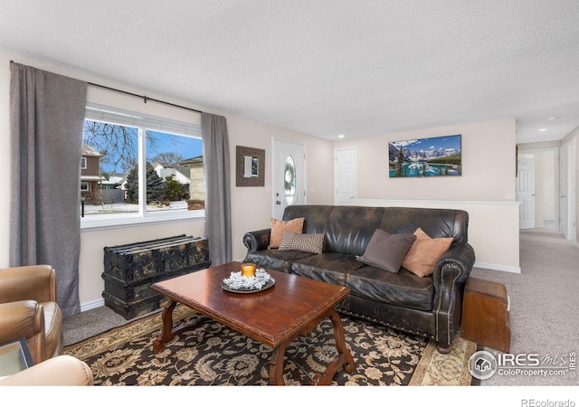 carpeted living room featuring a textured ceiling