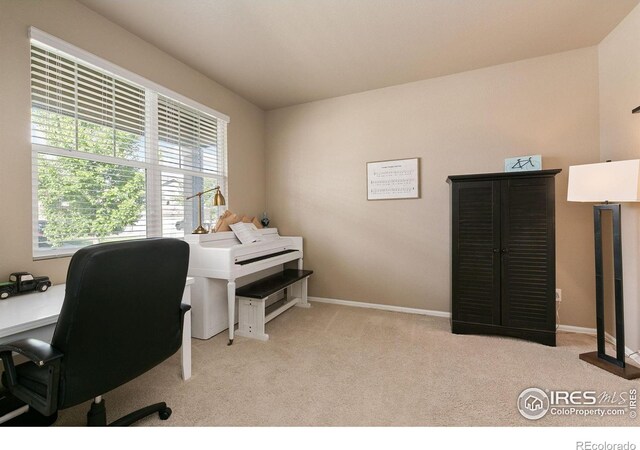 carpeted home office featuring baseboards