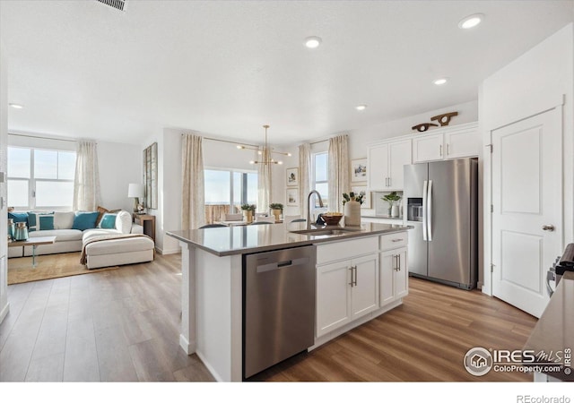 kitchen featuring sink, white cabinetry, an island with sink, and appliances with stainless steel finishes