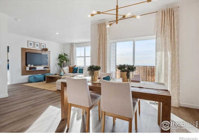 dining area featuring hardwood / wood-style flooring and an inviting chandelier