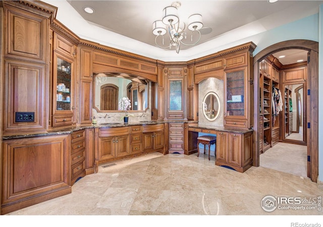 bathroom with vanity, decorative backsplash, and a chandelier