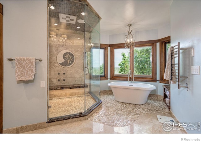 bathroom with shower with separate bathtub and a notable chandelier