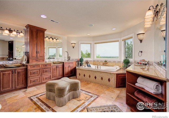 bathroom with vanity and tiled bath