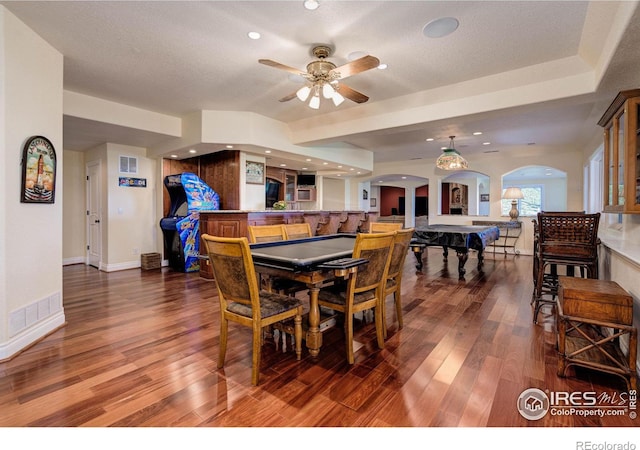 dining area featuring ceiling fan, wood-type flooring, and a textured ceiling