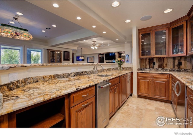 kitchen featuring light stone countertops, decorative backsplash, ceiling fan, and sink