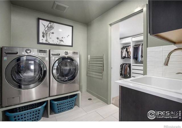 clothes washing area featuring cabinets, separate washer and dryer, and sink