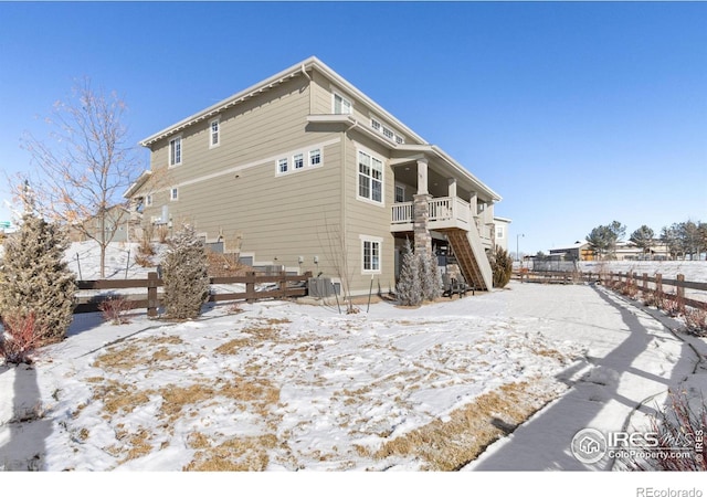 snow covered house featuring central air condition unit