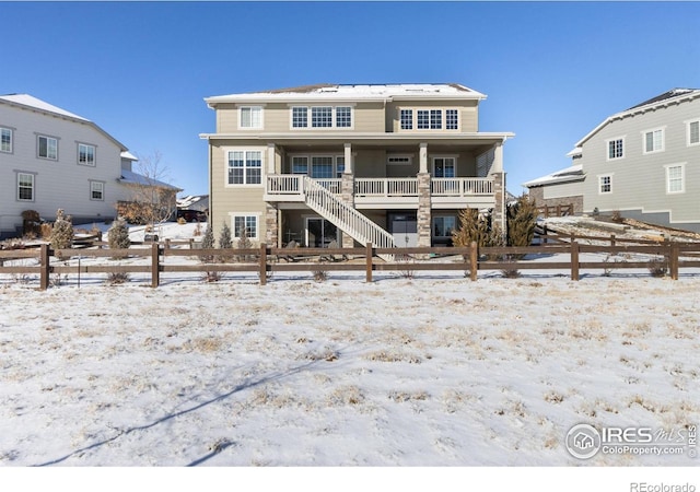 snow covered property with covered porch