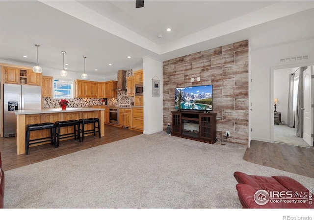 living room with recessed lighting, carpet floors, a fireplace, wood finished floors, and visible vents