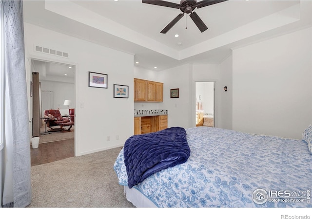 bedroom with recessed lighting, carpet flooring, visible vents, baseboards, and a tray ceiling