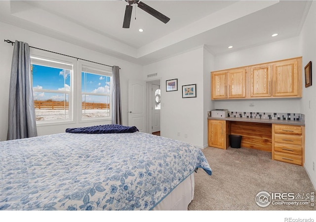 bedroom with recessed lighting, light colored carpet, visible vents, built in study area, and a raised ceiling