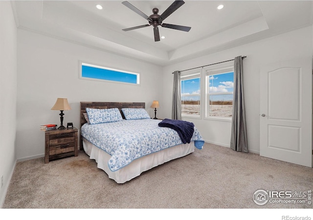 carpeted bedroom with a ceiling fan, a tray ceiling, baseboards, and recessed lighting