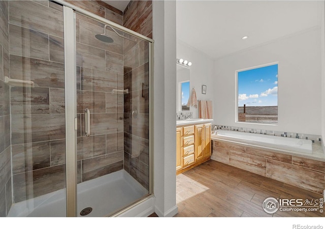 bathroom with vanity, wood finished floors, a shower stall, and a bath