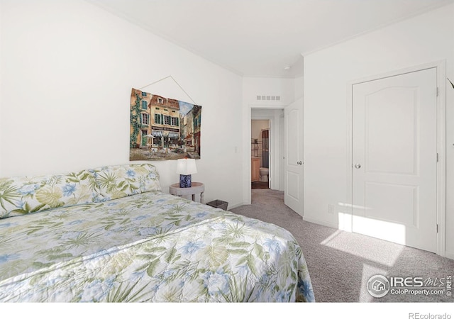 carpeted bedroom with visible vents and crown molding