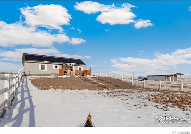 rear view of house featuring fence private yard and roof mounted solar panels