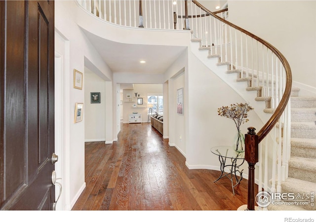 foyer featuring wood-type flooring and a high ceiling